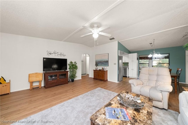 living room with vaulted ceiling, ceiling fan with notable chandelier, a textured ceiling, and light hardwood / wood-style flooring