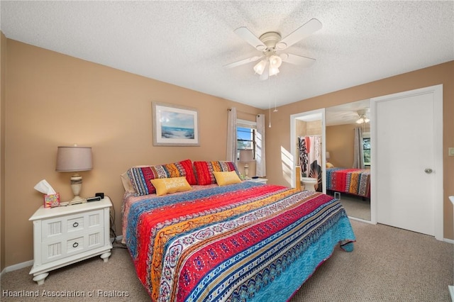 bedroom with ceiling fan, carpet floors, and a textured ceiling