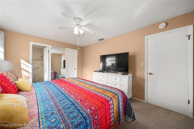 bedroom with ceiling fan, carpet floors, and a textured ceiling