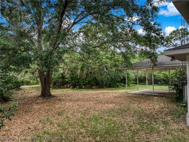9131 Bridle Path, Sebring, FL 33875 - view of green lawn featuring a patio area and a carport