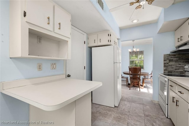9131 Bridle Path, Sebring, FL 33875 - kitchen with white appliances, light countertops, a peninsula, a chandelier, and white cabinets