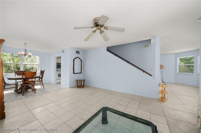 9131 Bridle Path, Sebring, FL 33875 - living area featuring a chandelier, light tile patterned floors, stairs, and ceiling fan