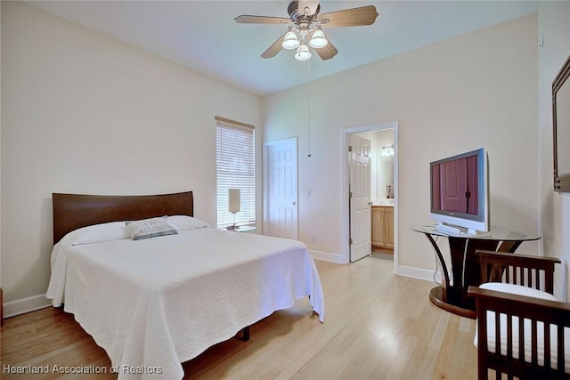 bedroom featuring light wood-type flooring, baseboards, a ceiling fan, and ensuite bathroom