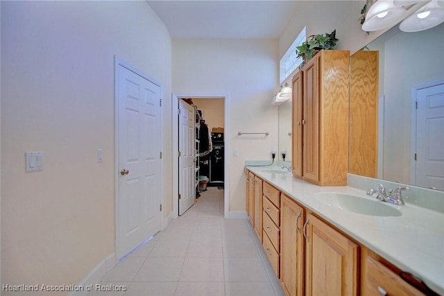 full bath featuring tile patterned flooring, a sink, baseboards, and double vanity