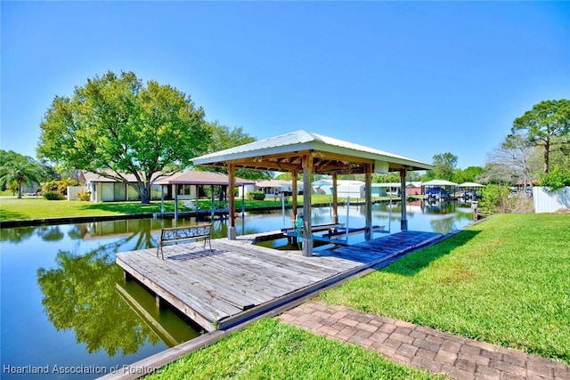 view of dock featuring a water view and a yard