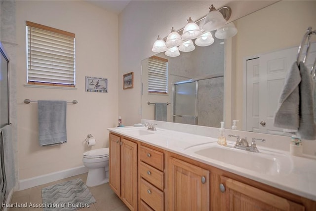 bathroom with a sink, a shower stall, toilet, and double vanity