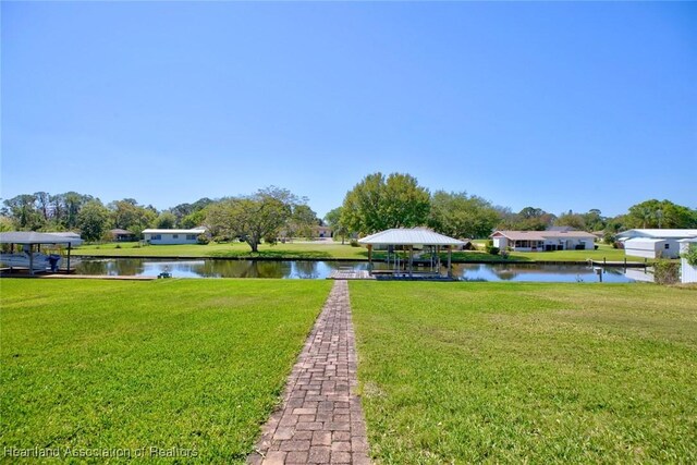 view of dock featuring a yard, a water view, and a gazebo