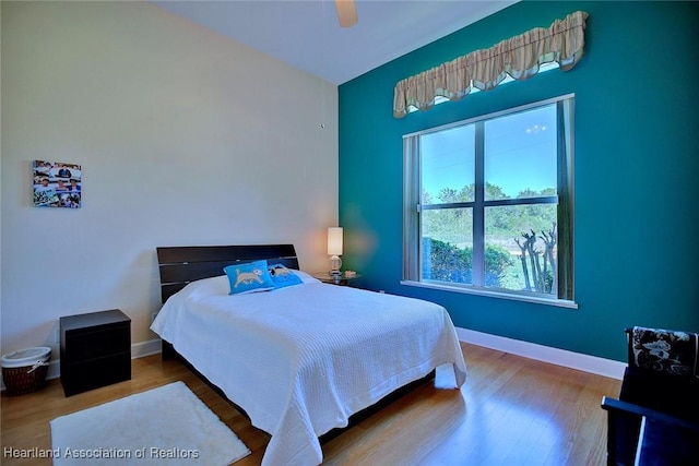 bedroom with wood finished floors, a ceiling fan, and baseboards