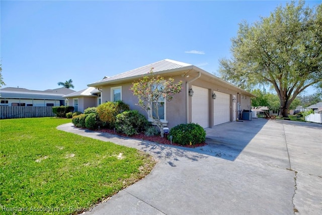 ranch-style home featuring driveway, a garage, stucco siding, fence, and a front yard