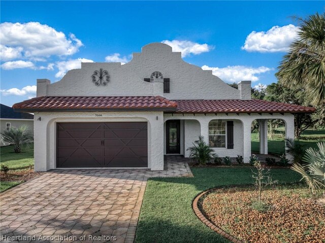 mediterranean / spanish-style house with a front lawn and a garage