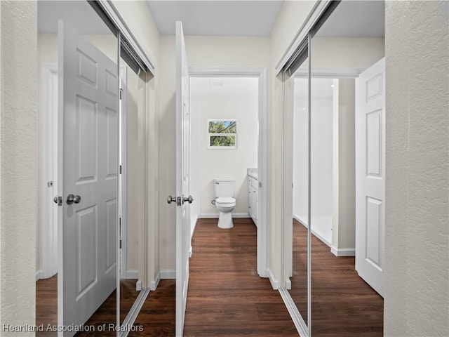 corridor with dark hardwood / wood-style flooring