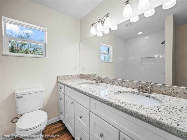 bathroom with hardwood / wood-style floors, vanity, a healthy amount of sunlight, and toilet