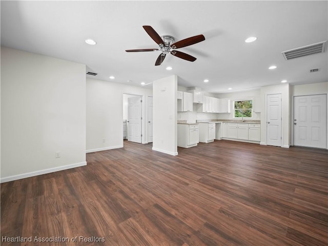 unfurnished living room with ceiling fan and dark hardwood / wood-style flooring