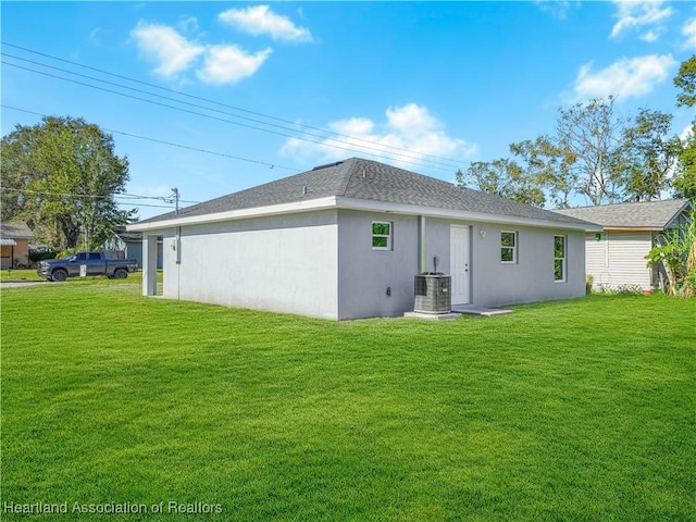 back of property with a yard and central air condition unit