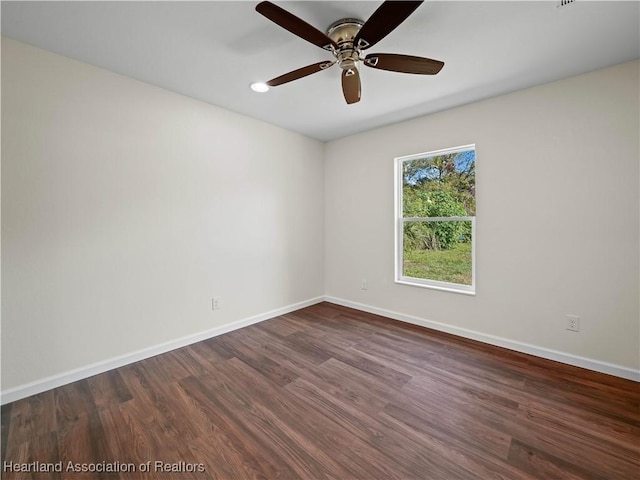 unfurnished room with ceiling fan and dark wood-type flooring