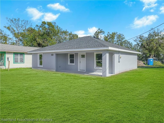 back of property with a patio area and a yard