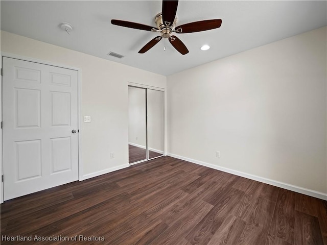 unfurnished bedroom featuring a closet, ceiling fan, and dark wood-type flooring