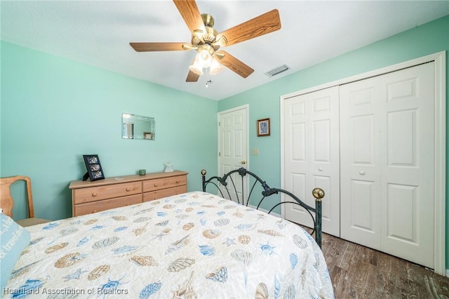 bedroom with dark hardwood / wood-style floors, ceiling fan, and a closet