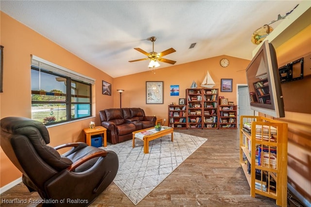 living room with hardwood / wood-style flooring, vaulted ceiling, and ceiling fan