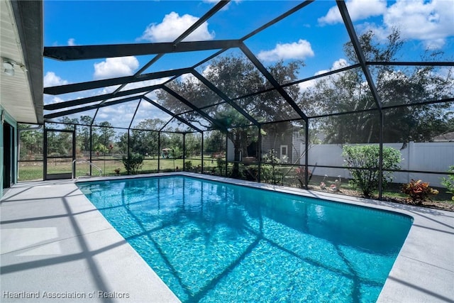 view of swimming pool featuring a lanai and a patio area