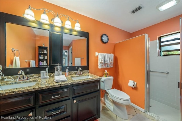 bathroom featuring a shower with door, vanity, tile patterned floors, and toilet