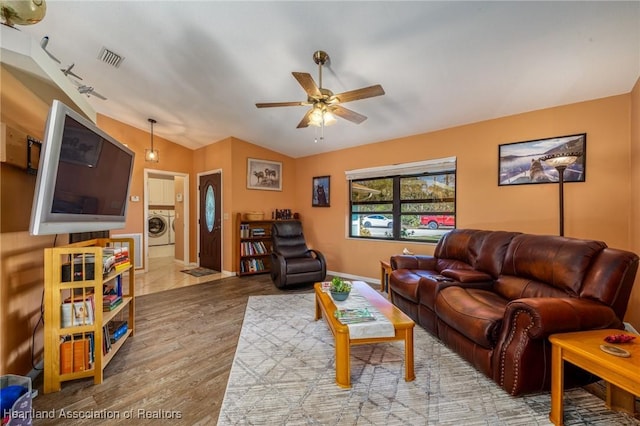 living room with light hardwood / wood-style flooring, washer / clothes dryer, vaulted ceiling, and ceiling fan