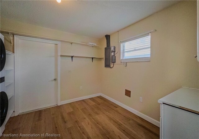 956 Shamrock Dr, Sebring, FL 33875 - laundry room featuring stacked washer / dryer, light wood-type flooring, and baseboards