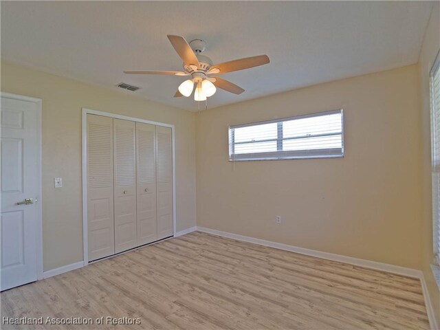 956 Shamrock Dr, Sebring, FL 33875 - unfurnished bedroom featuring light wood-style floors, a closet, baseboards, and a ceiling fan