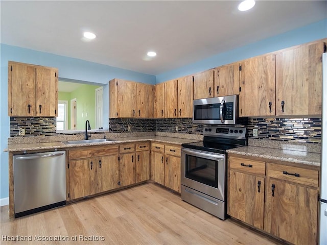 956 Shamrock Dr, Sebring, FL 33875 - kitchen featuring appliances with stainless steel finishes, a sink, light wood-type flooring, tasteful backsplash, and recessed lighting