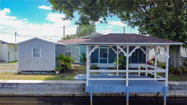 956 Shamrock Dr, Sebring, FL 33875 - rear view of property with a sunroom, a wooden deck, and roof with shingles