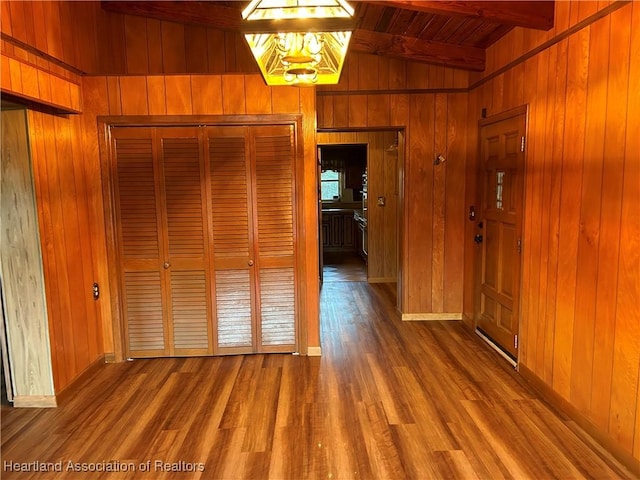 interior space featuring beamed ceiling, hardwood / wood-style floors, wooden walls, and wood ceiling