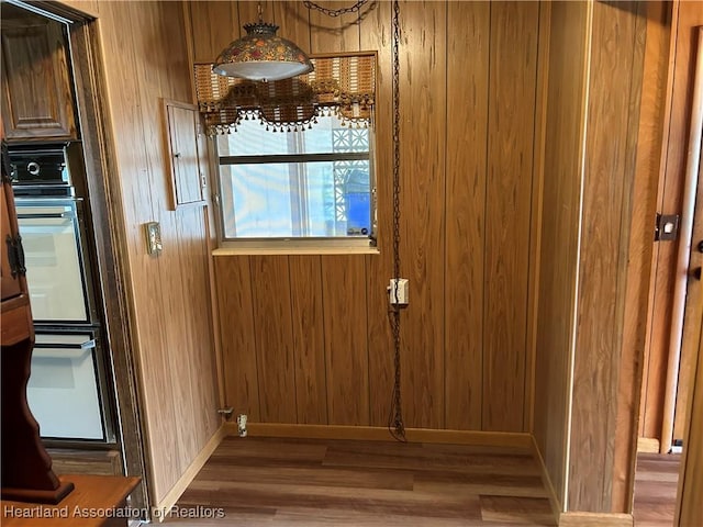 entryway featuring dark wood-type flooring and wooden walls