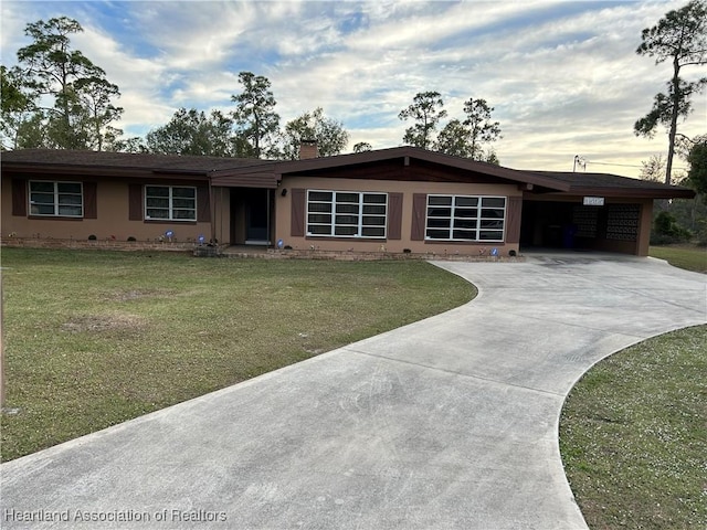 ranch-style house with a carport and a lawn