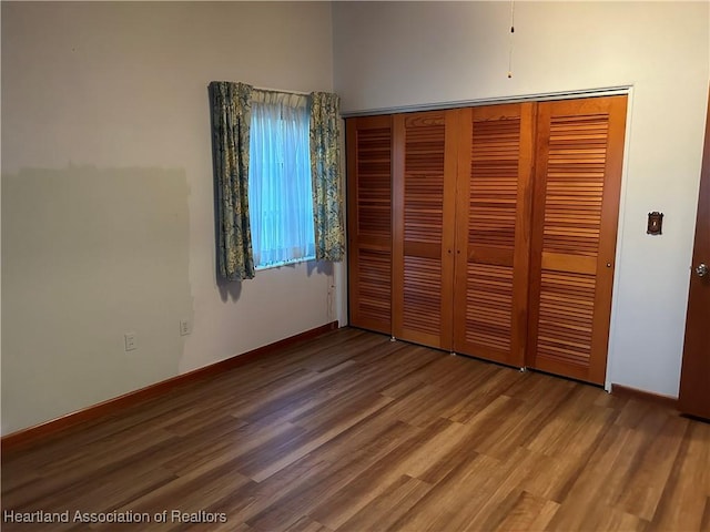 unfurnished bedroom with a closet and hardwood / wood-style floors