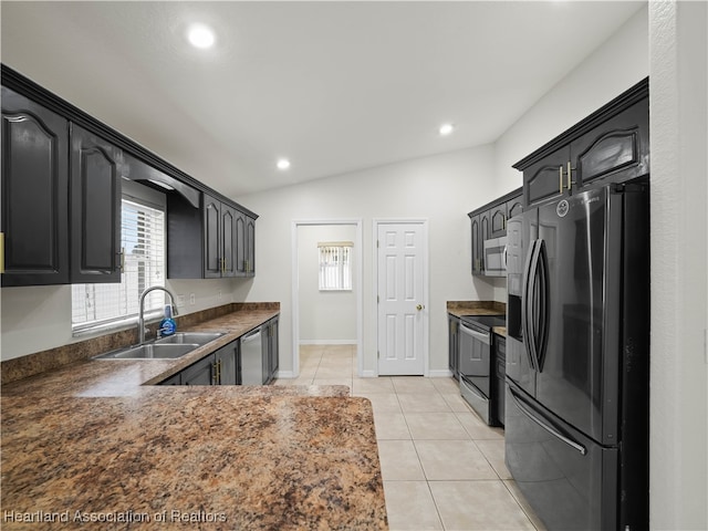 kitchen with lofted ceiling, light tile patterned floors, sink, and appliances with stainless steel finishes