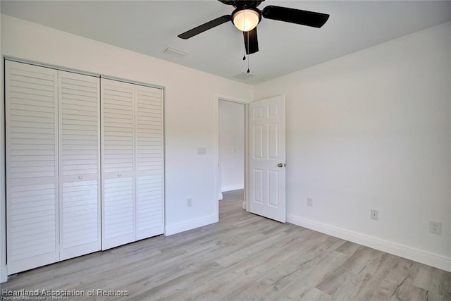 unfurnished bedroom with visible vents, a ceiling fan, wood finished floors, a closet, and baseboards