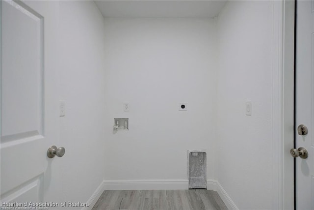 clothes washing area with light wood finished floors, baseboards, hookup for an electric dryer, hookup for a washing machine, and laundry area