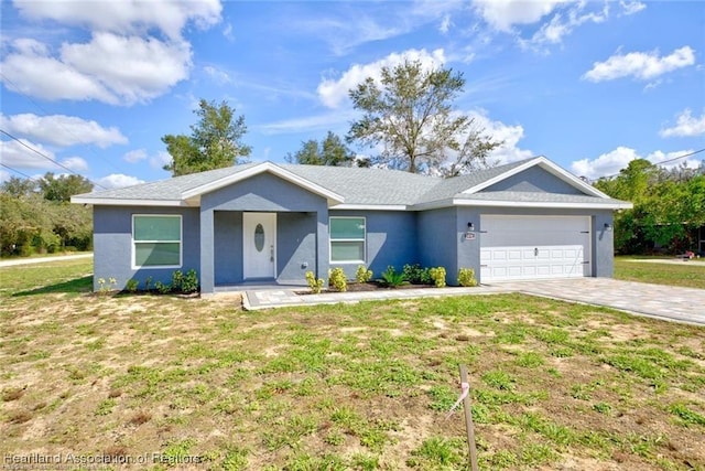 single story home with a front yard, decorative driveway, a garage, and stucco siding