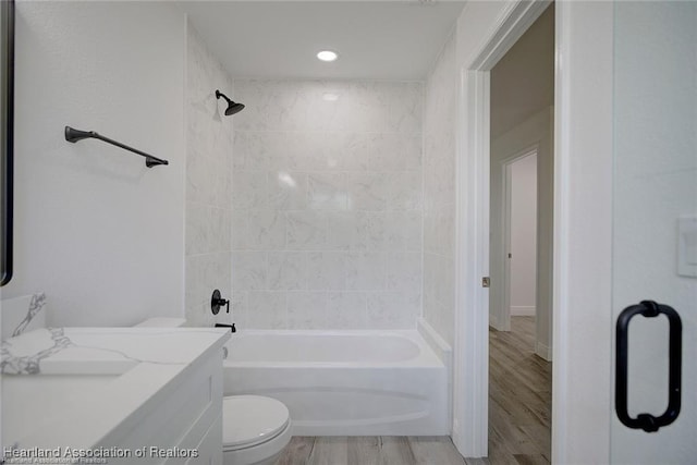 full bath featuring bathtub / shower combination, toilet, and wood finished floors