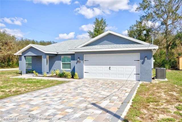 single story home featuring central air condition unit, roof with shingles, stucco siding, decorative driveway, and a garage