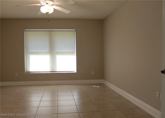 empty room with ceiling fan and light tile patterned floors