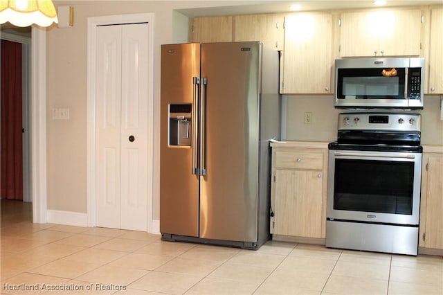 kitchen with light brown cabinetry, stainless steel appliances, and light tile patterned floors