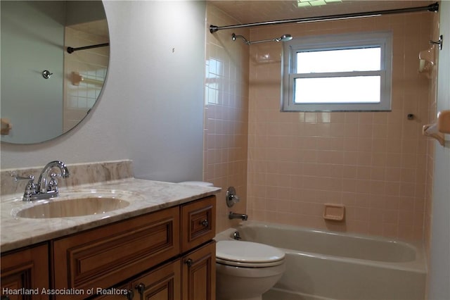 full bathroom with vanity, tiled shower / bath combo, and toilet