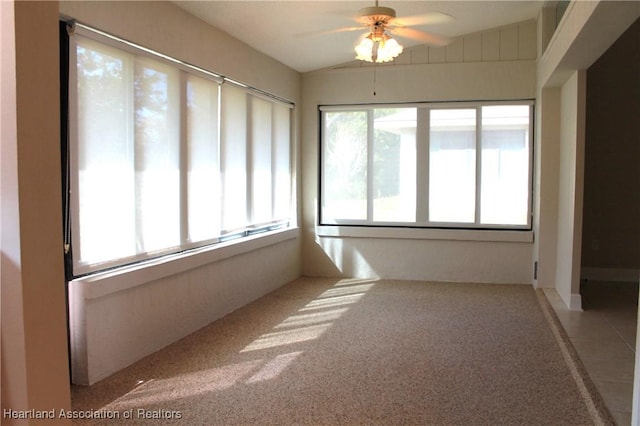 unfurnished sunroom with ceiling fan and vaulted ceiling