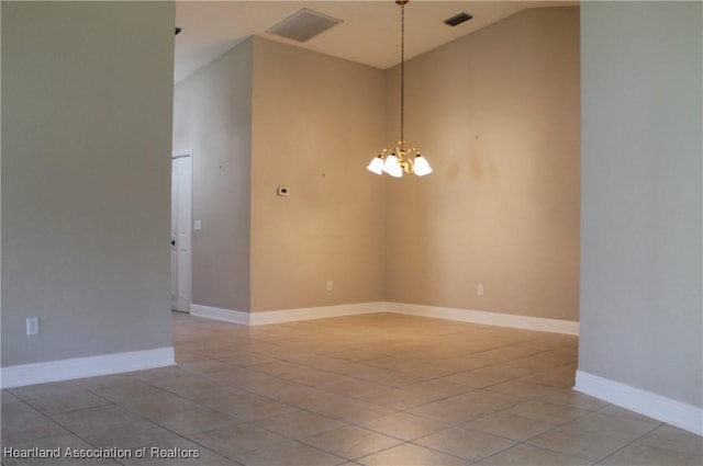 spare room featuring vaulted ceiling, an inviting chandelier, and light tile patterned flooring