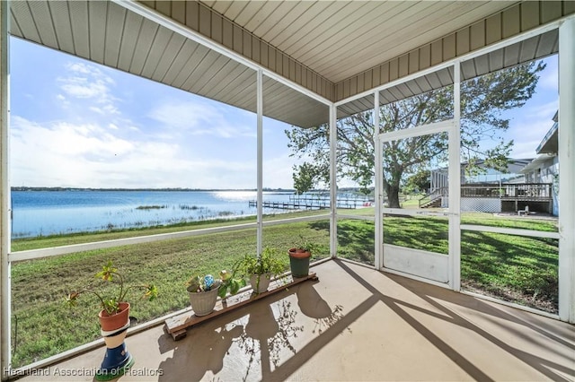 unfurnished sunroom featuring a water view