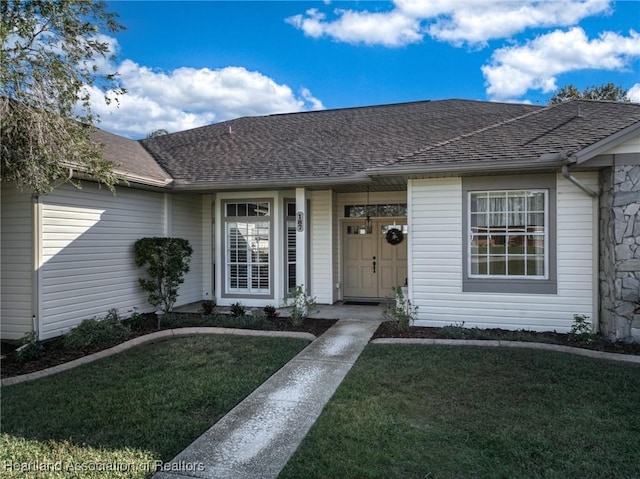 view of exterior entry with a yard