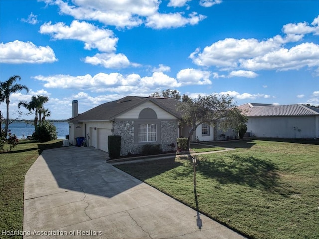 ranch-style home featuring a garage, a water view, and a front yard