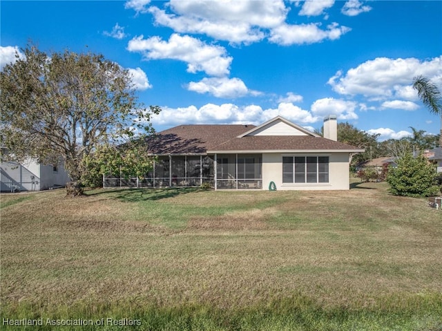 rear view of property with a lawn and a sunroom