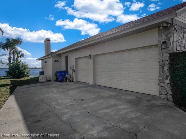 view of home's exterior with a water view and a garage